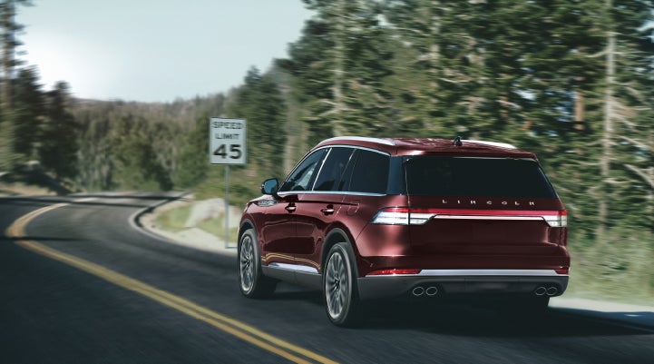A 2024 Lincoln Aviator® SUV is being driven on a winding mountain road | Cavalier Lincoln in Chesapeake VA