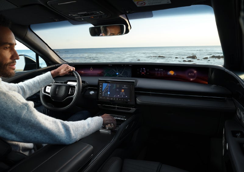 A driver of a parked 2024 Lincoln Nautilus® SUV takes a relaxing moment at a seaside overlook while inside his Nautilus. | Cavalier Lincoln in Chesapeake VA